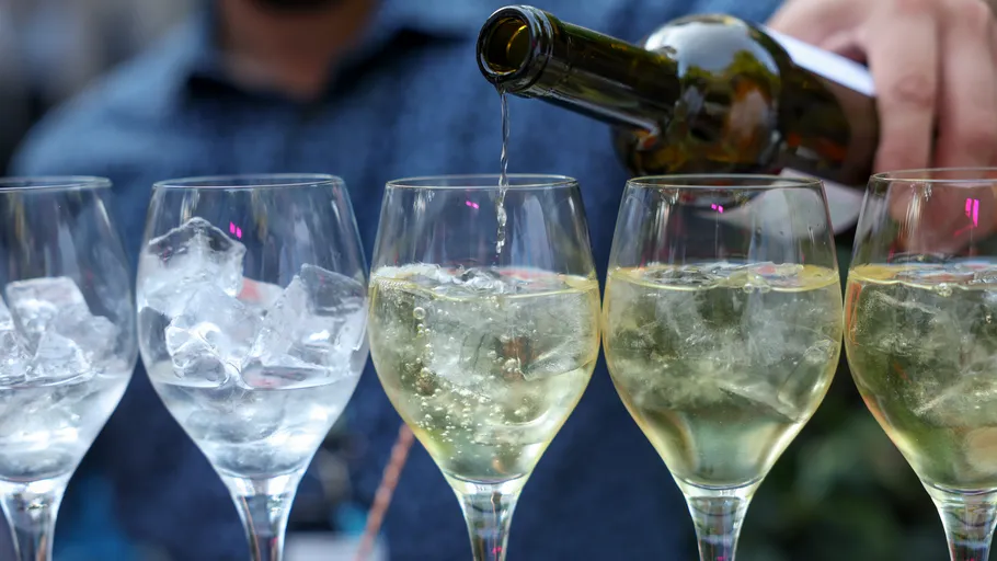 White wine poured into glasses with ice.