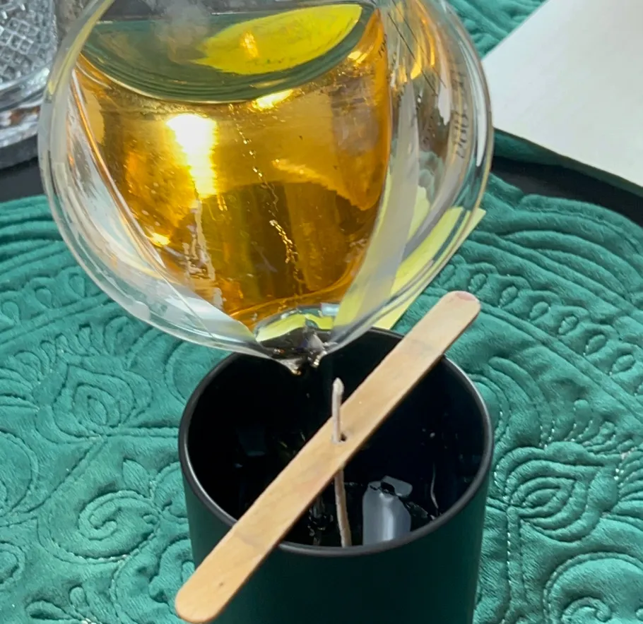 Wax being poured into a candle mold.
