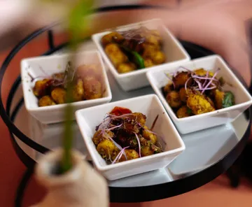 Four bowls of seasoned potatoes on table.