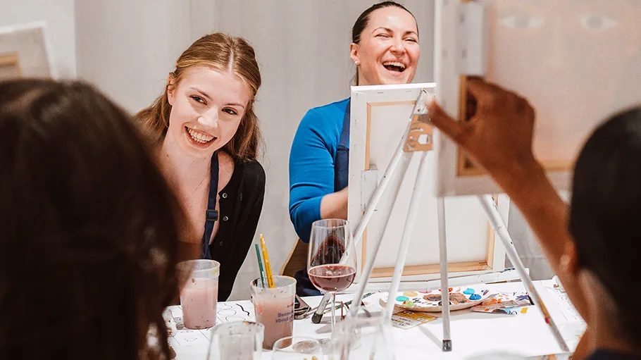 Women laughing during painting class.
