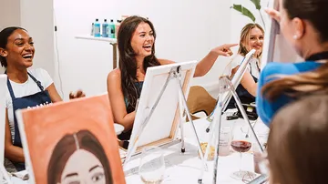 People laughing while painting in class.
