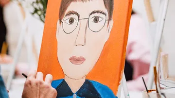 Hand painting a portrait with orange background.