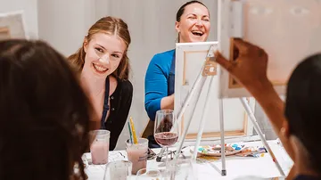Women laughing at a painting class.
