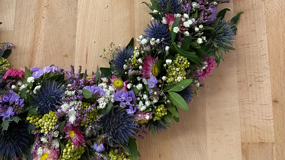 Blumenkranz auf Holztischoberfläche.