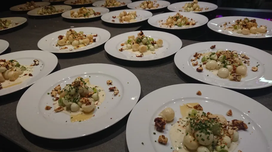 Plates with gourmet food arranged on table.