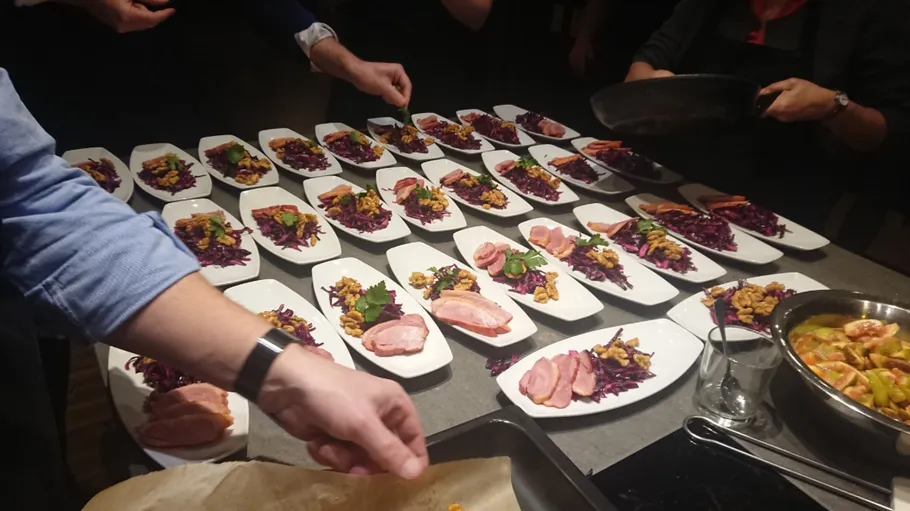 Chefs plating dishes in a kitchen.