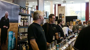 People discussing at a whisky exhibition.