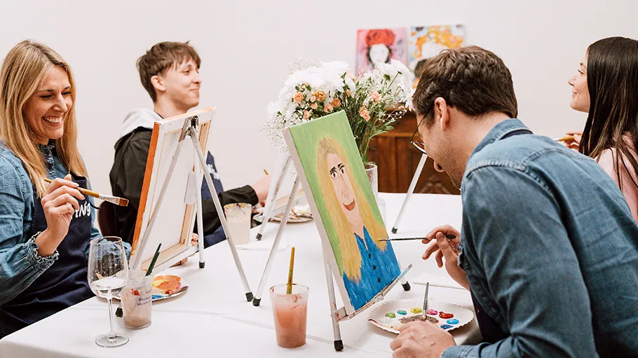 Group painting together at art class table.