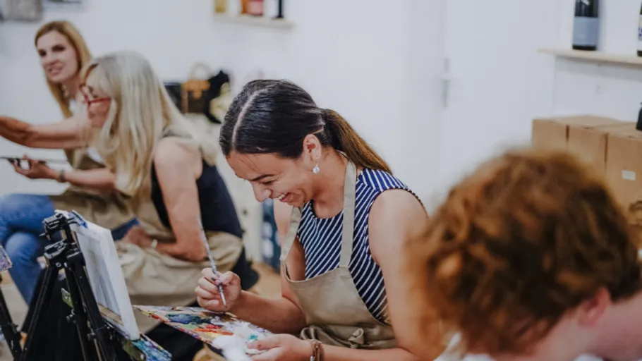 Women painting in an art class setting.