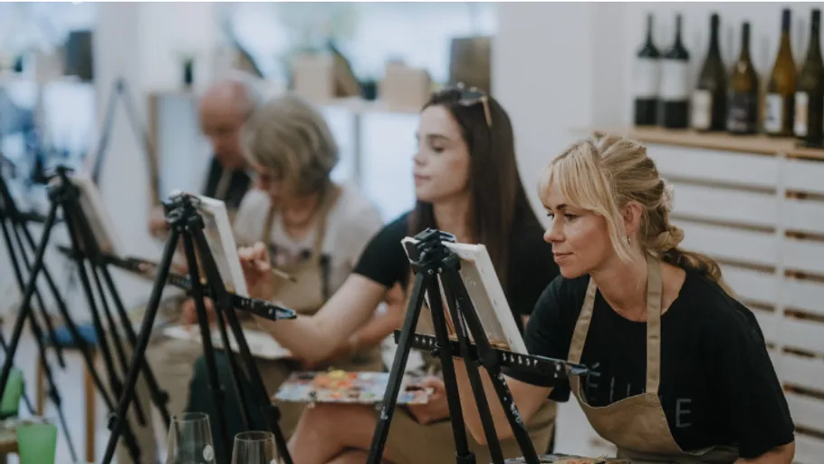 Erwachsene malen auf Leinwänden im Kunstkurs.