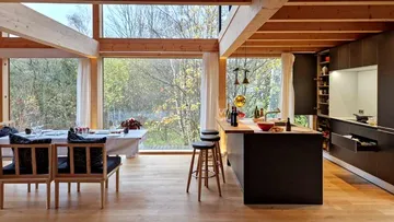 Moderne Küche mit Holz und großen Fenstern.