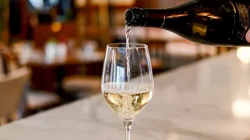 Wine poured into glass on table.