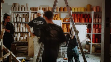 People working in yarn-filled studio.