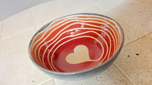Keramikschale mit Herzmuster auf Tisch.