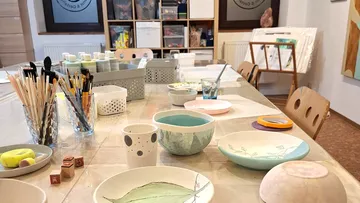 Painted bowls and art supplies on table.