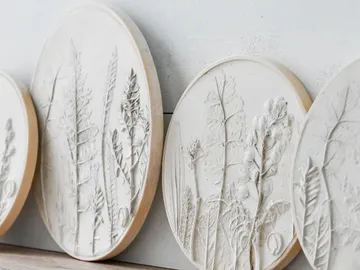 Round reliefs with plant motifs hang on the wall.