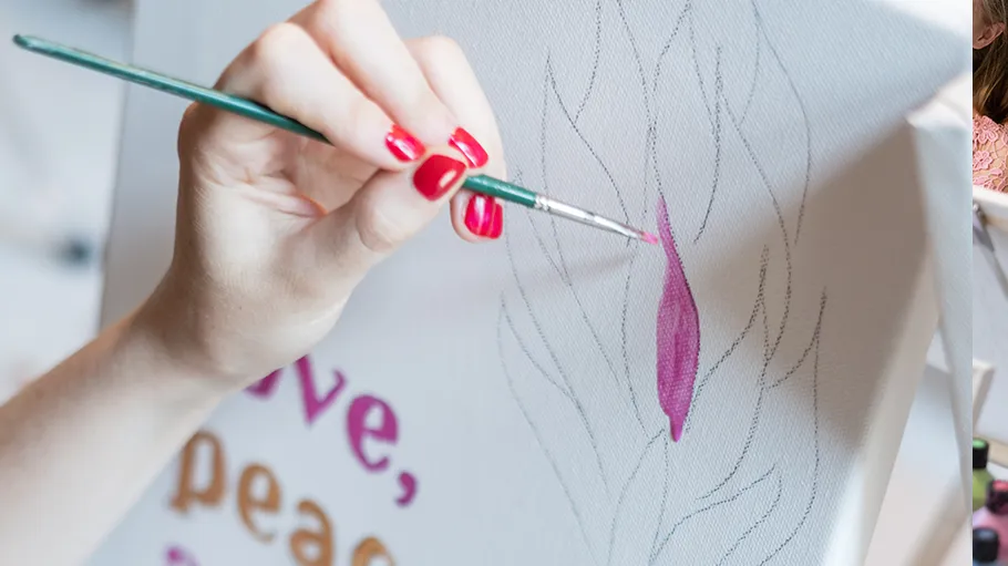 Hand painting canvas with pink brush strokes.