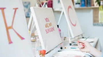 Canvas with text, held by a person.