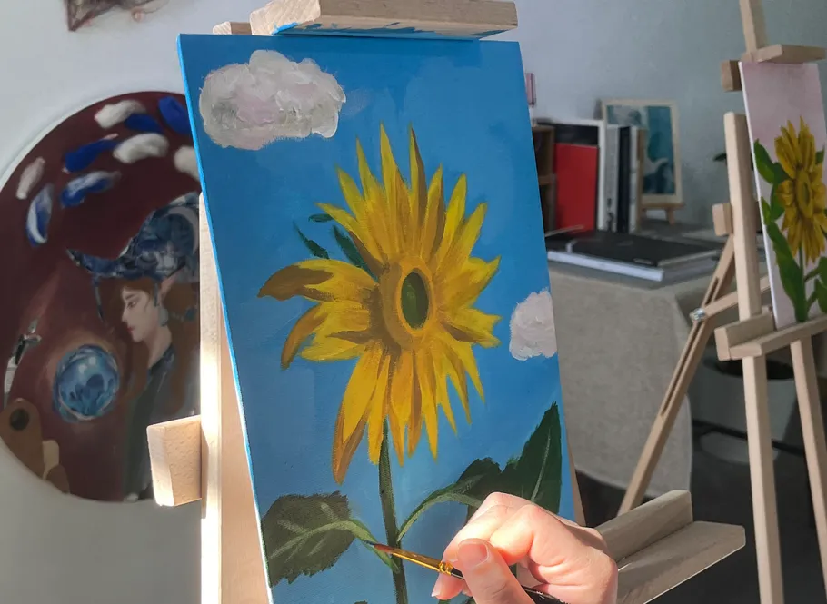 Hand painting sunflower on canvas in studio.
