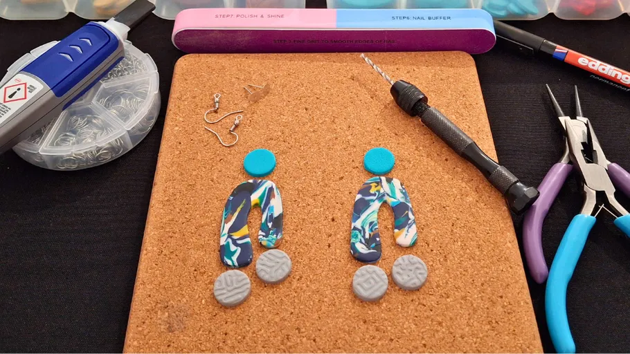 Jewelry-making tools and materials on corkboard.