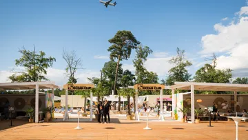 Outdoor-Club-Szene mit Flugzeug darüber.