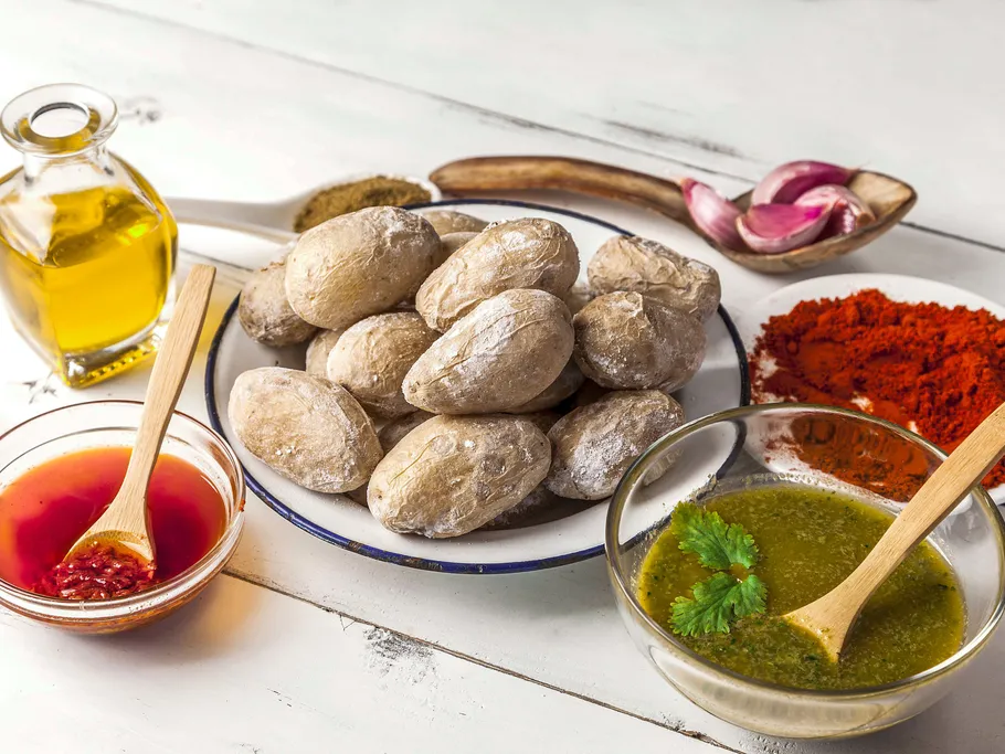 Potatoes, spices and sauces arranged on a table.