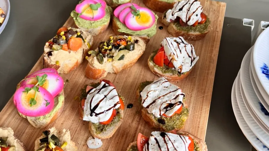 Bunte Crostini mit verschiedenen Belägen auf Holzbrett.