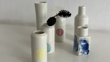 Small ceramic vases on white surface.