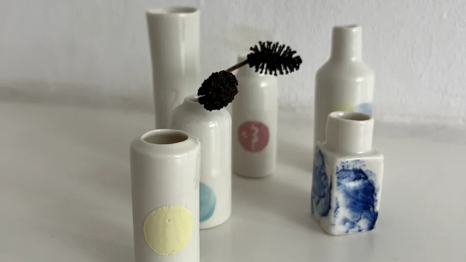 Small ceramic vases on white surface.