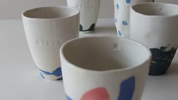 Keramiktassen mit bunten Mustern auf einem Tisch.