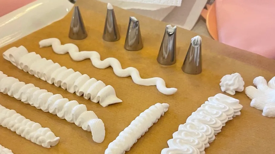 Icing nozzles with piped designs on parchment.