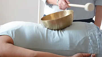 Klangschale auf dem Rücken einer Person.