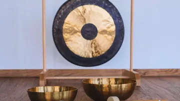 Gong and singing bowls in room.