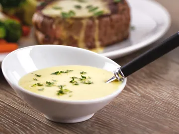 Bowl with sauce attracts attention, spoon is ready.