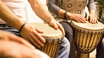People playing drums in a room.