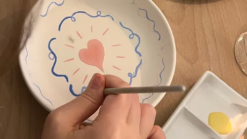 Hand malt Herzdesign auf Keramikteller.