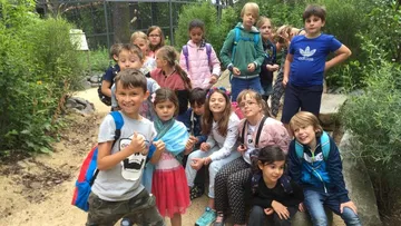 Group of children posing in a garden.