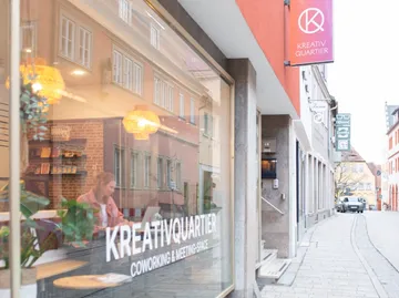 Frau arbeitet in einem Coworking-Space, Straßenansicht.