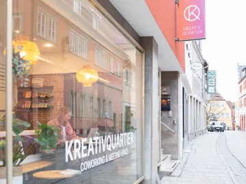 Frau arbeitet in einem Coworking-Space, Straßenansicht.