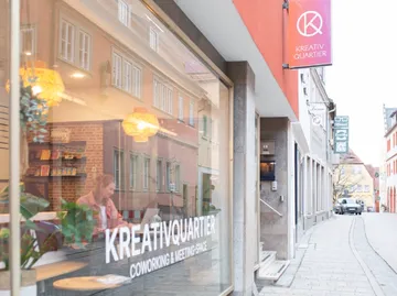Coworking-Bereich mit Straßenblick und Spiegelungen.