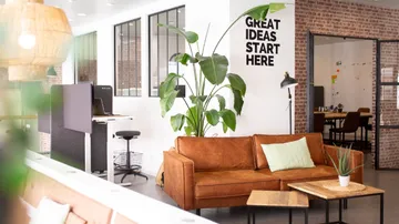 Cozy office lounge with a brown sofa.