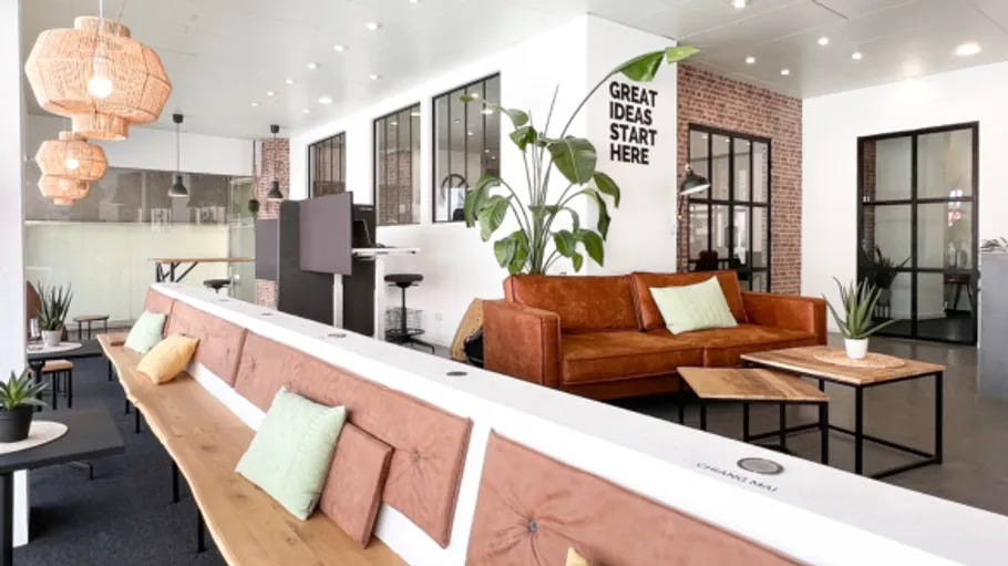 Modern office with seating and plants.