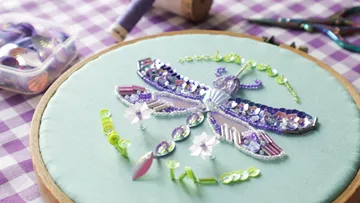 Beaded dragonfly embroidery on fabric hoop.
