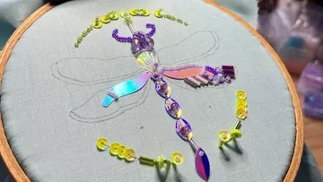 Beaded dragonfly embroidery on light fabric.
