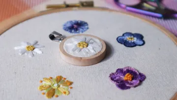 Gestickte Blumen auf Stoff im Stickrahmen.