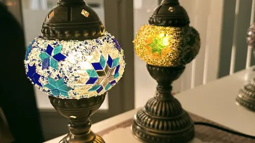 Bunte Mosaiklampen leuchten auf einem Tisch.