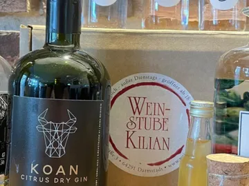 Green gin bottle stands next to a wine bar box.