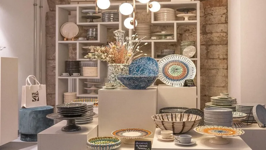 Ceramic bowls displayed on white shelves in store.
