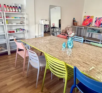 Art studio with colorful chairs and table.