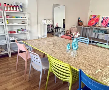 Colorful chairs around crafting table in art studio.